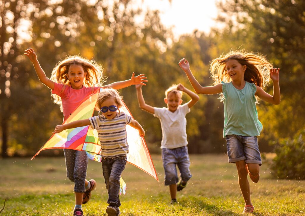 group of happy children running in public park